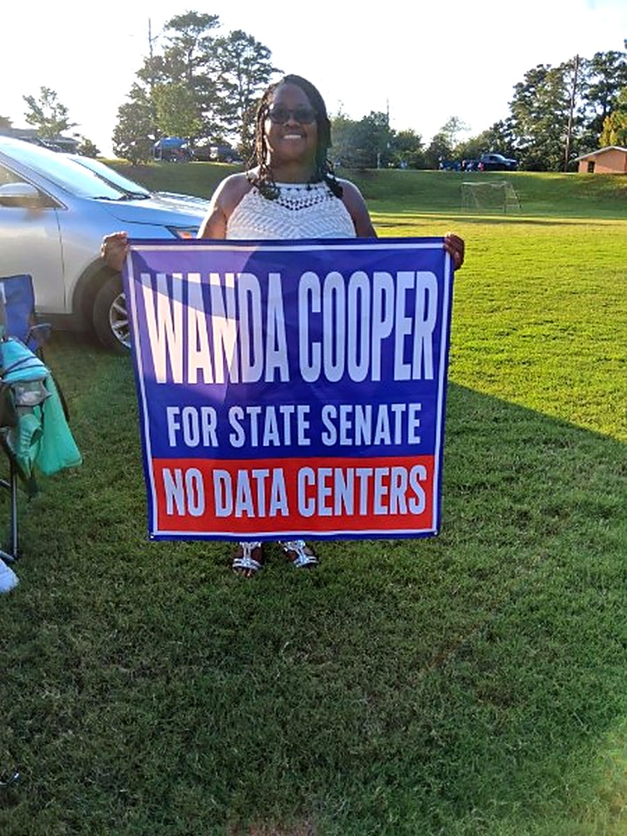 Supporter holding a Wanda Cooper for State Senate "No Data Centers" sign