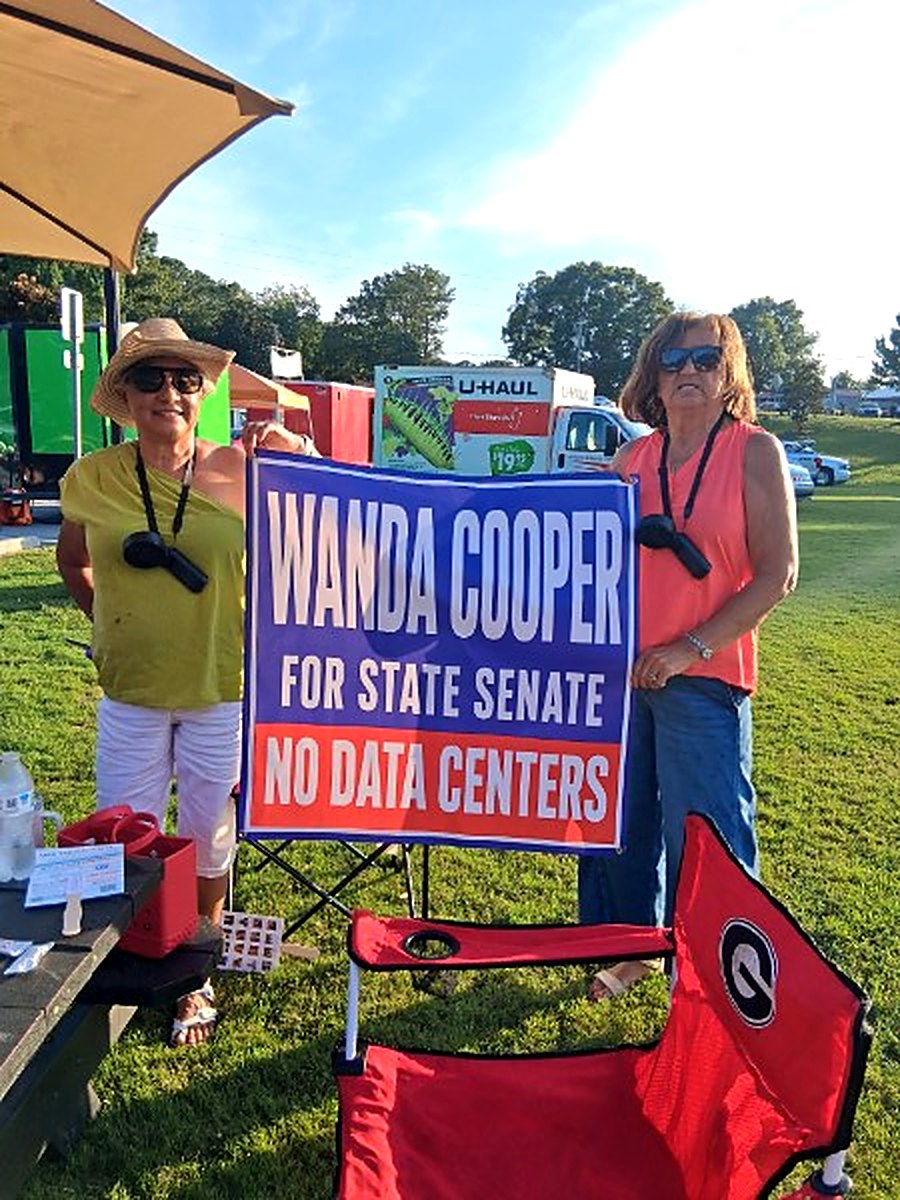 Two supporters with a Wanda Cooper for State Senate sign at a community event