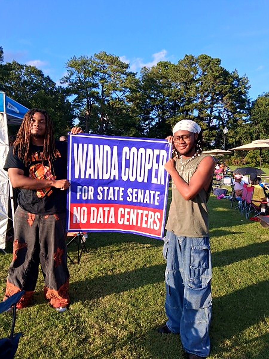 Young supporters holding a Wanda Cooper "No Data Centers" sign in the park